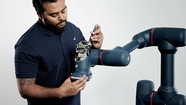 An Agile Robots employee repairing a Yu 5 Industrial robot