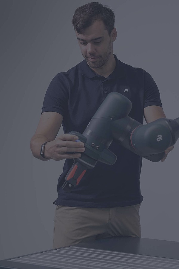 An Agile Robots employee handling the Yu 5 Industrial robot