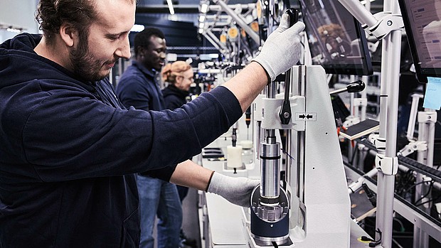 Agile Robots employees working on various robot components