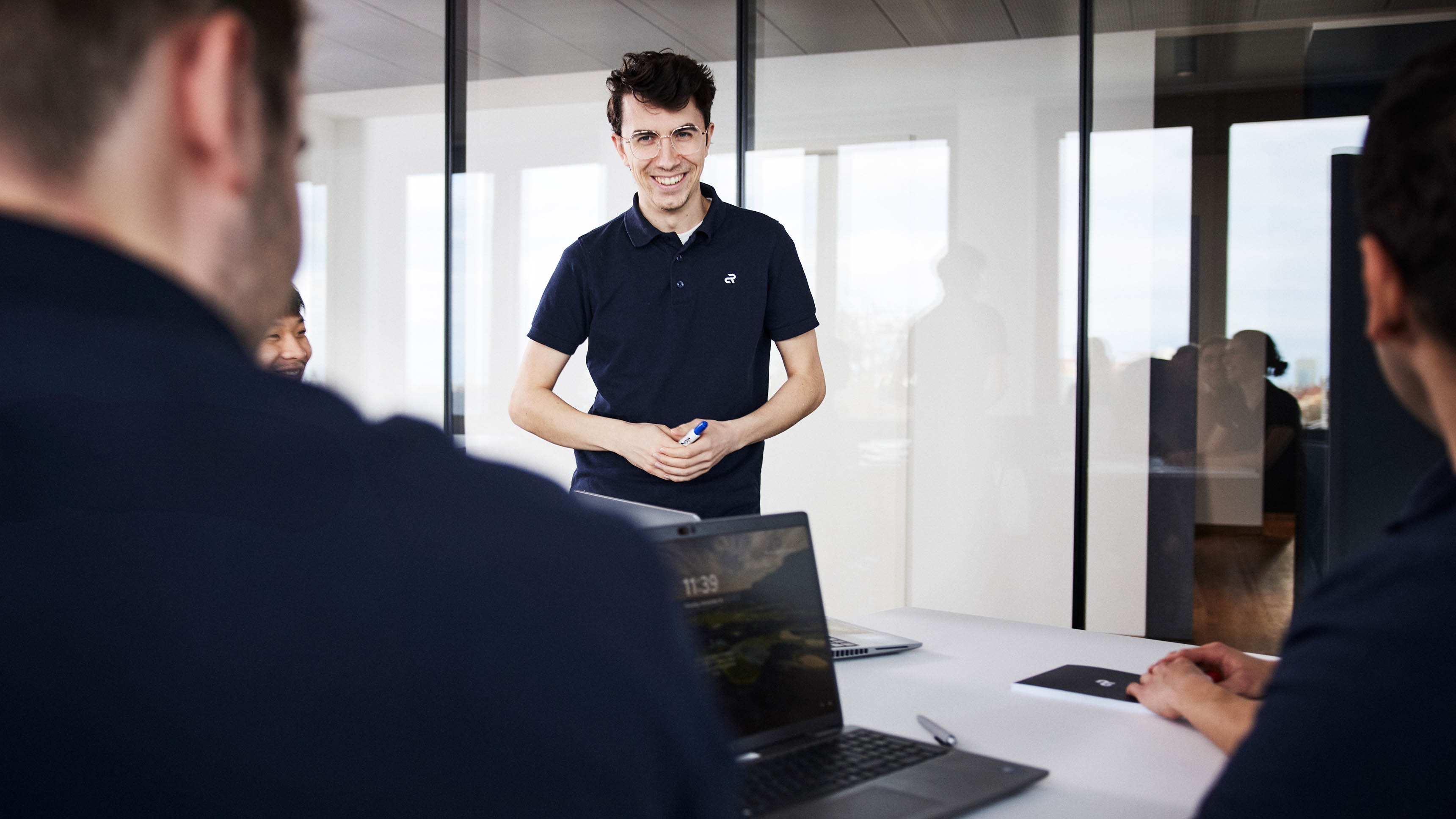 An Agile Robots employee addressing a group of people in a business meeting 